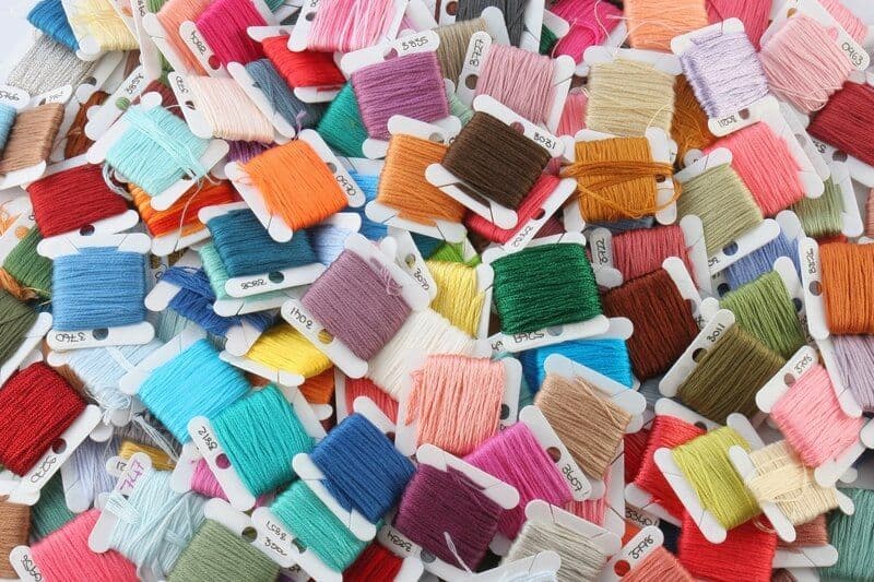 Image de broderie colorée avec des motifs floraux et des fils de différentes couleurs